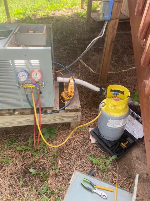 AC repair technician charging an outdoor air conditioning condenser
